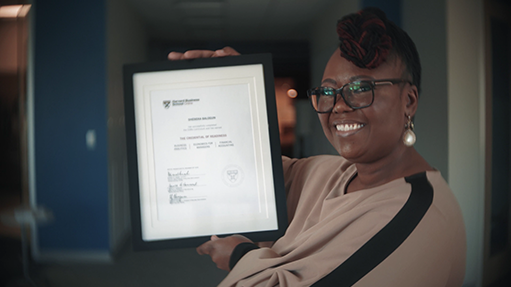 Sheneka holding her HBS Online certificate